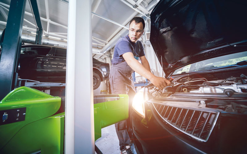 Kostenloser Lichttest Auto mit angeschaltetem Licht in der Werkstatt