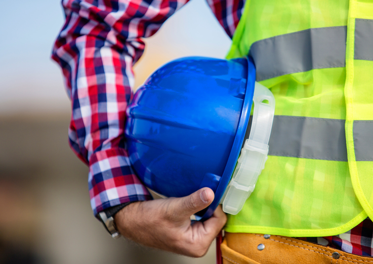 Construction worker holding a blue helmet