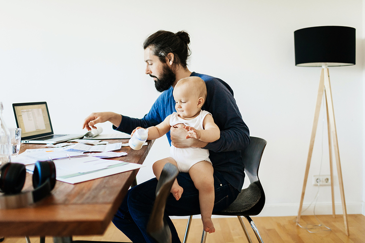1072470420 Single Father Working While Holding Baby